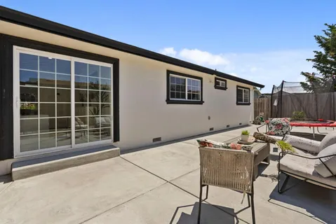 a backyard of a house with table and chairs