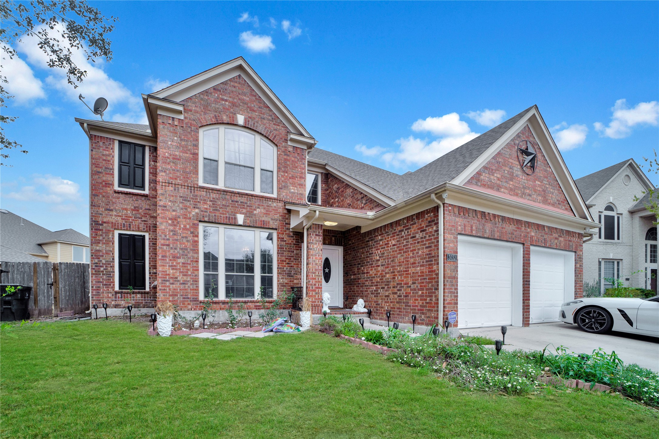 View of front of property featuring brick siding, an attached garage, and driveway