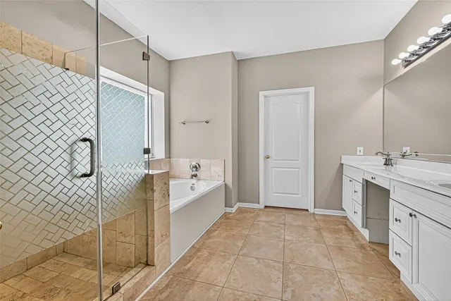 a spacious bathroom with a double vanity sink a mirror and a bathtub