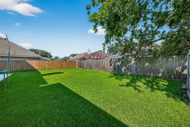 a view of yard with green space and wooden fence