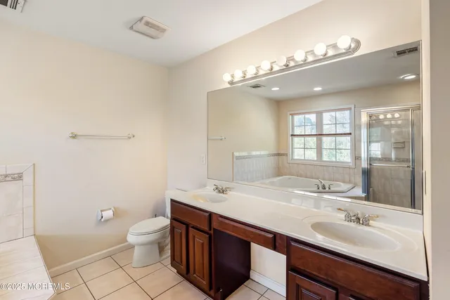 a bathroom with a sink a toilet a mirror and shower