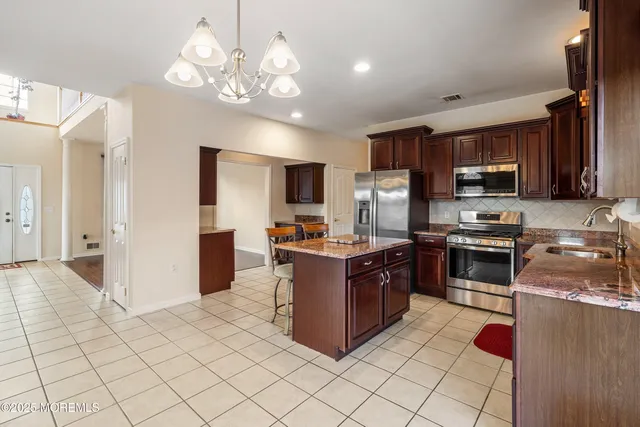 a kitchen with stainless steel appliances granite countertop a refrigerator and a stove top oven