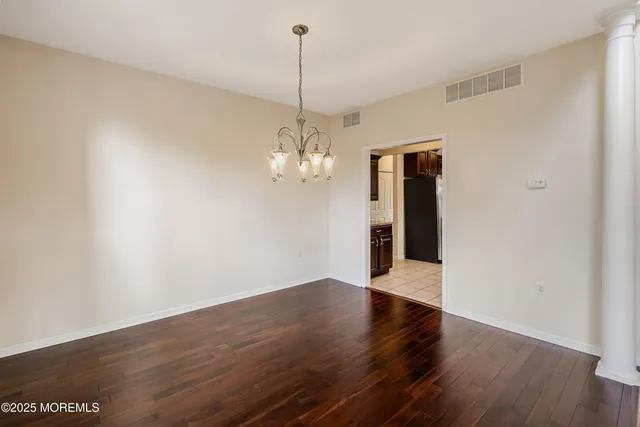 a view of a room with wooden floor and chandelier