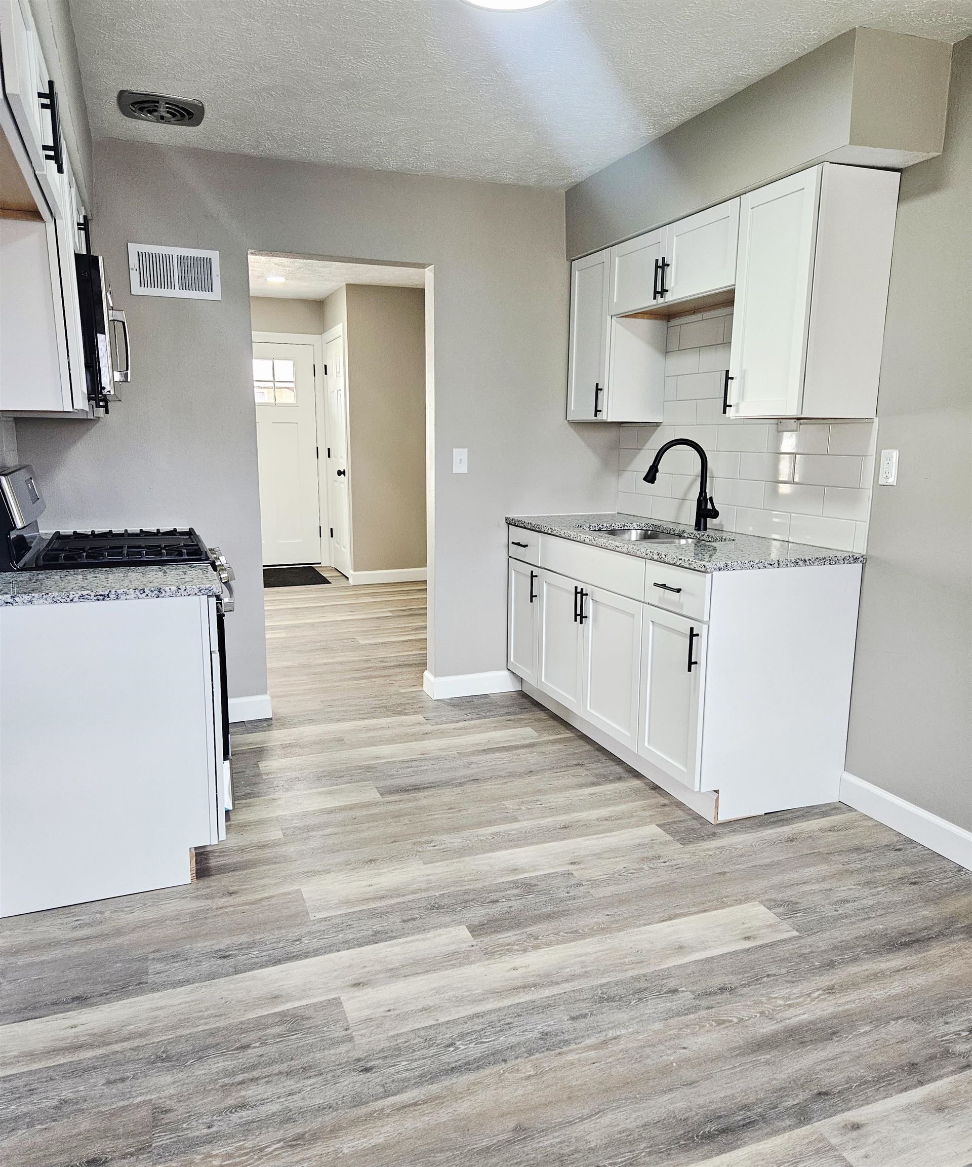 3216 North Winnebago Street Rockford, IL 61103 - Photo 14 of 18 a kitchen with stainless steel appliances granite countertop a sink stove and wooden floor
