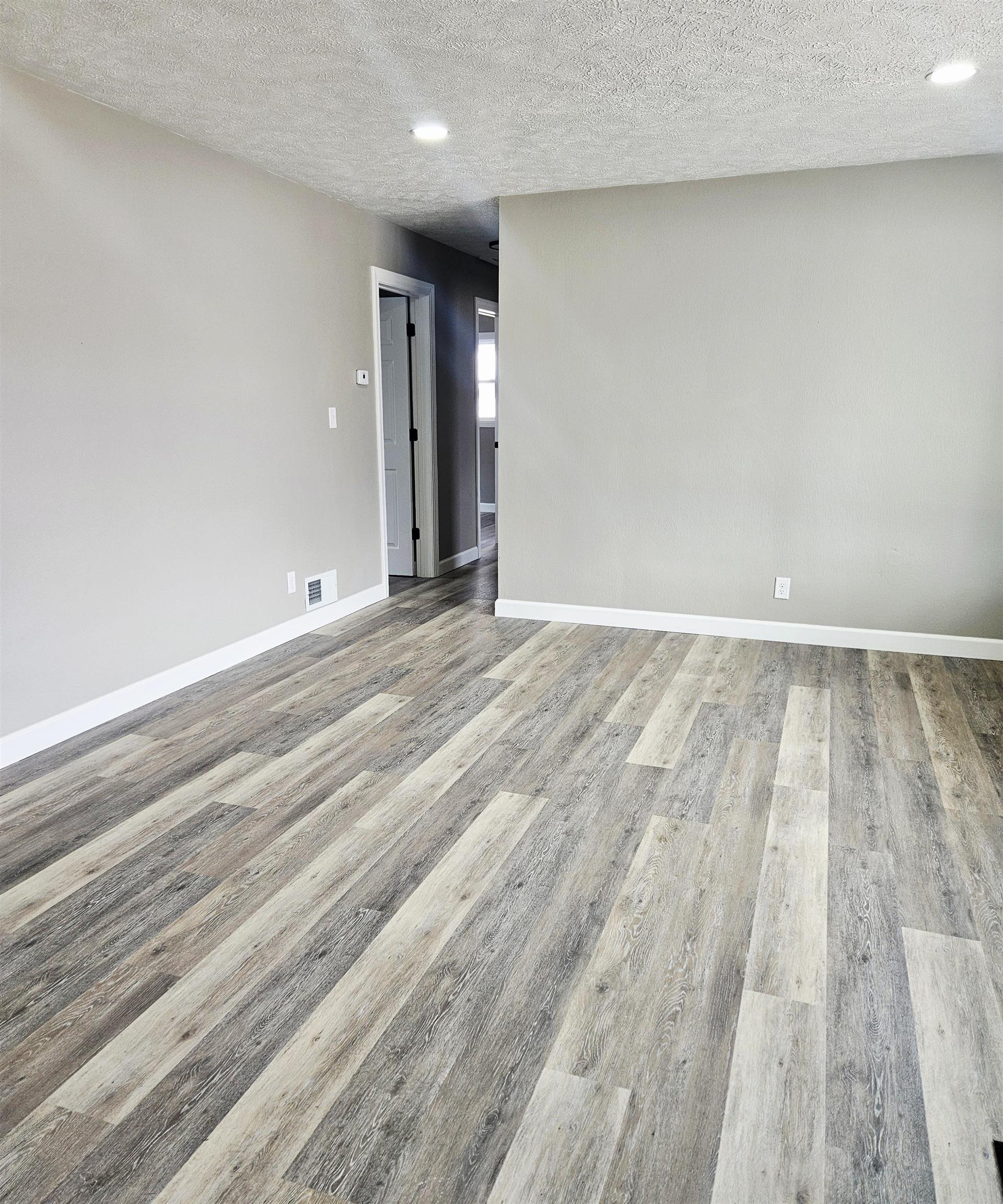 3216 North Winnebago Street Rockford, IL 61103 - Photo 4 of 18 an empty room with wooden floor and windows