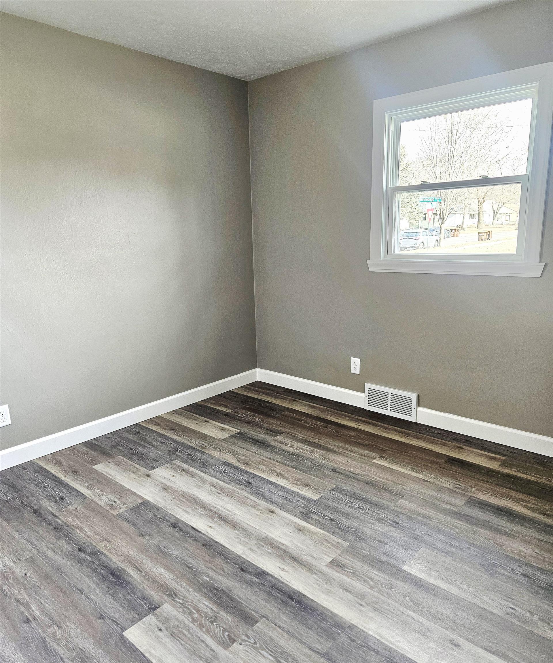 3216 North Winnebago Street Rockford, IL 61103 - Photo 6 of 18 a view of a room with wooden floor and a window