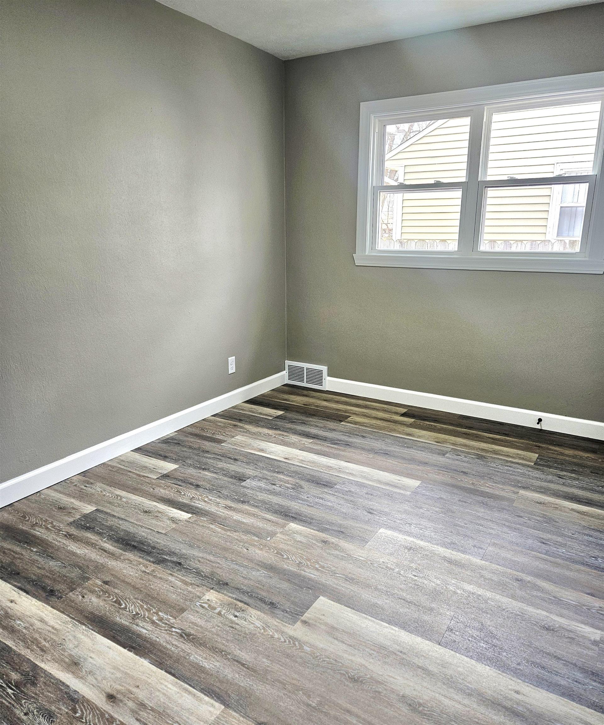 3216 North Winnebago Street Rockford, IL 61103 - Photo 10 of 18 an empty room with wooden floor and windows