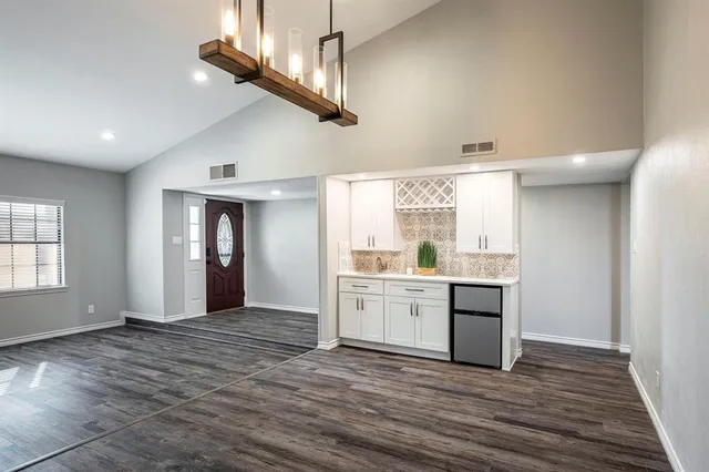a sink with white cabinets and wooden floor