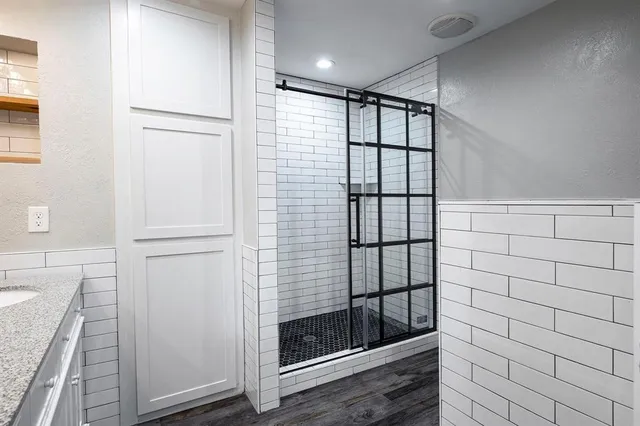 a bathroom with a granite countertop sink mirror and shower