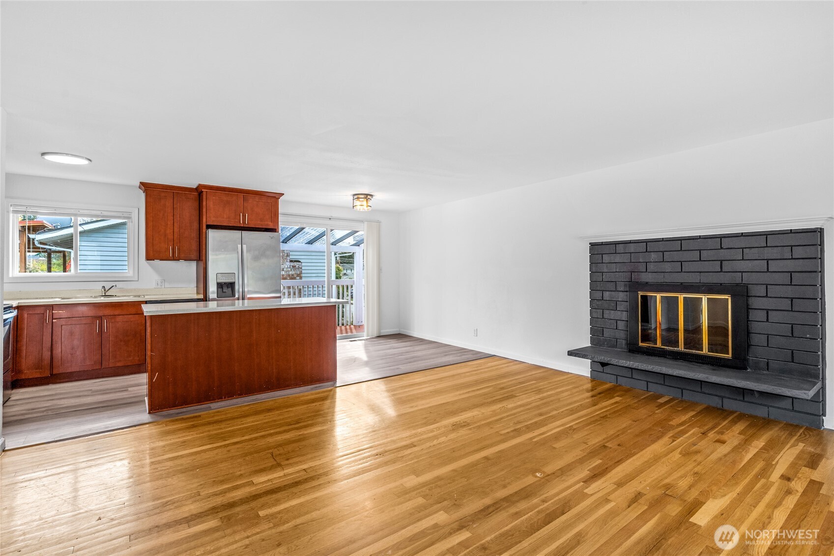 12703 Southeast 163rd Street Renton, WA 98058 - Photo 4 of 21 a view of kitchen and empty room with wooden floor