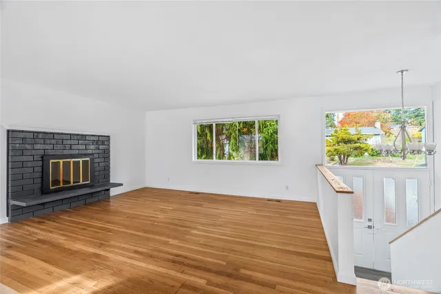 a view of an empty room with a fireplace and a window