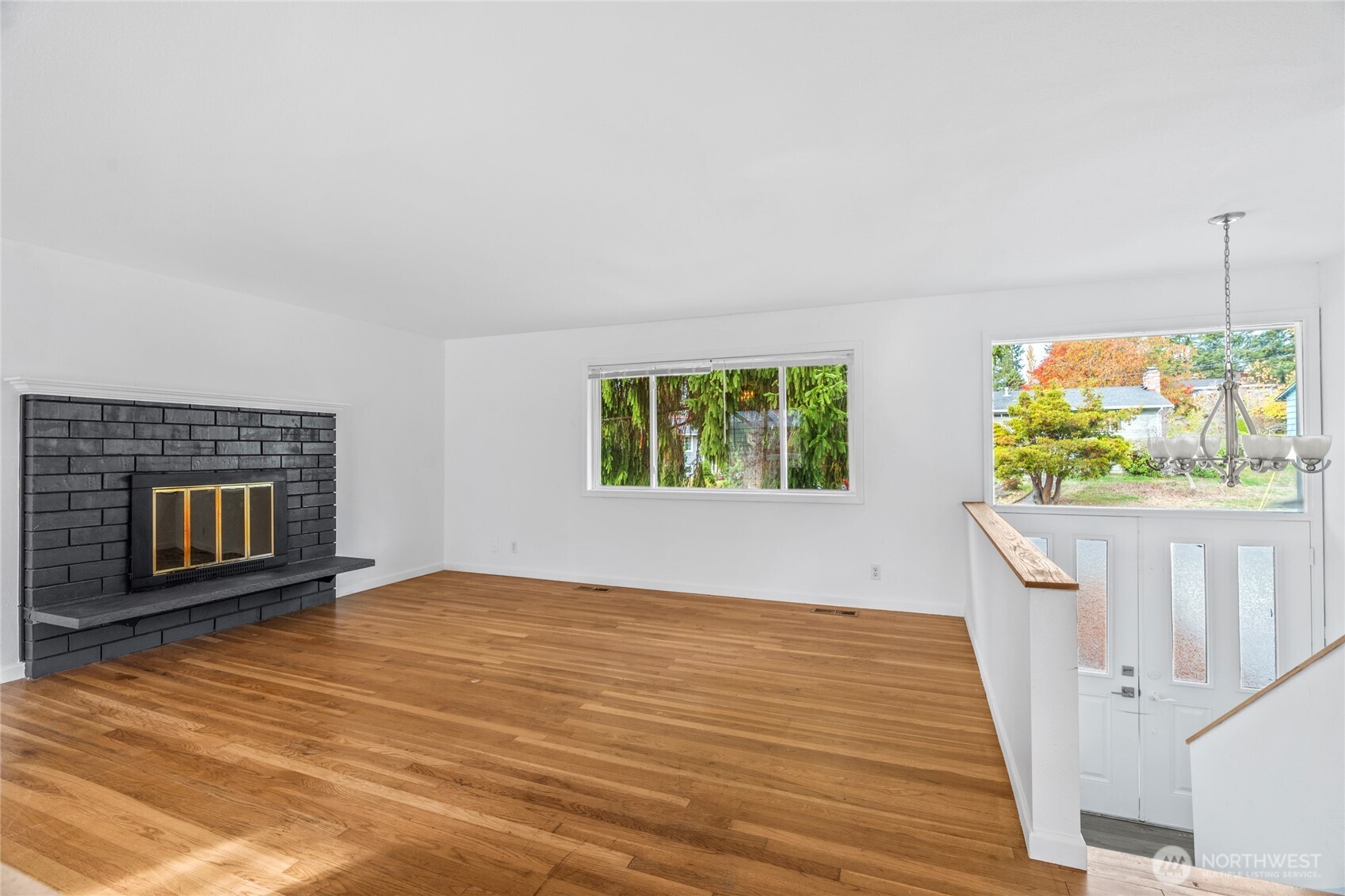 12703 Southeast 163rd Street Renton, WA 98058 - Photo 6 of 21 a view of an empty room with a fireplace and a window