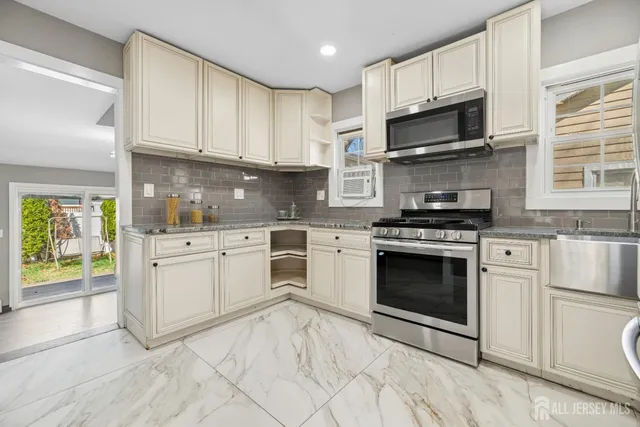 a kitchen with white cabinets stainless steel appliances and sink