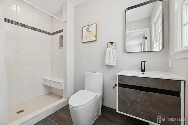 a bathroom with a toilet a sink and mirror