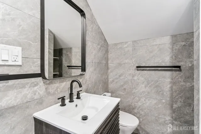 a bathroom with a sink a toilet and a mirror