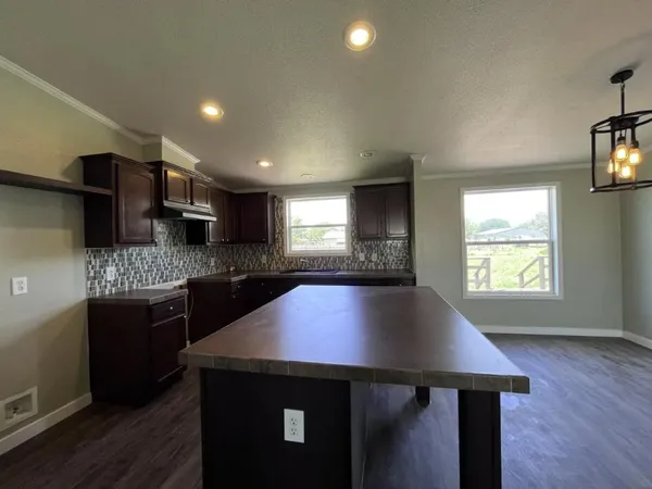 a kitchen with stainless steel appliances granite countertop a sink a stove and a wooden floors