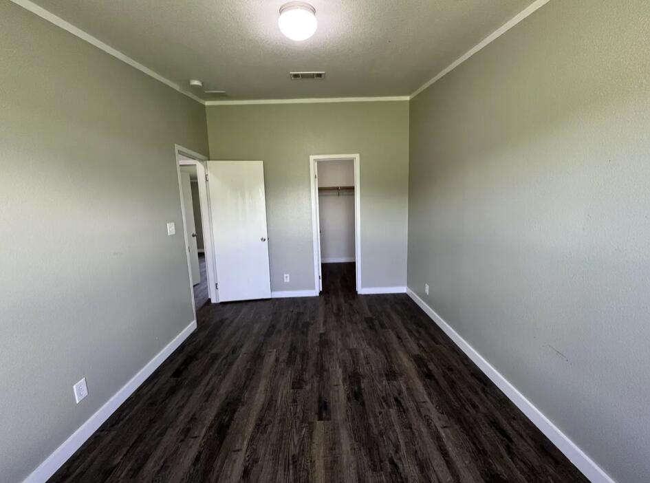 107 Grant Street Smyer, TX 79367 - Photo 20 of 22 a view of an empty room with wooden floor and a window