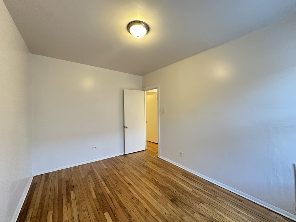 7149 South Constance Avenue, Unit 1E Chicago, IL 60649 - Photo 17 of 20 a view of a room with wooden floor and fan