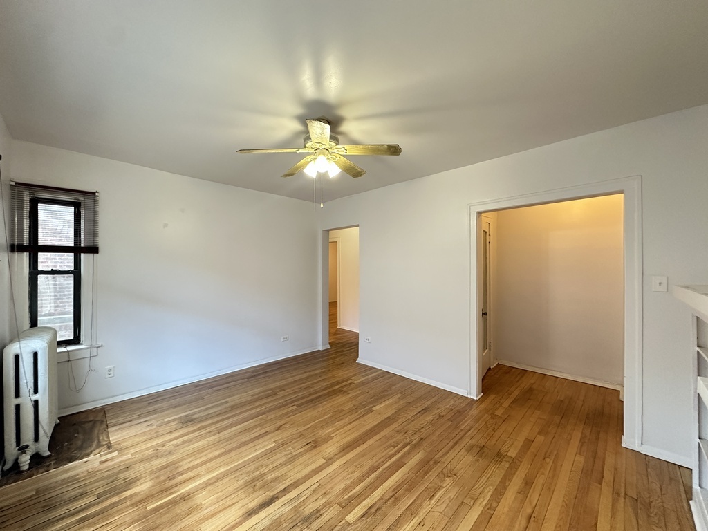 7149 South Constance Avenue, Unit 1E Chicago, IL 60649 - Photo 10 of 20 wooden floor in an empty room with a window