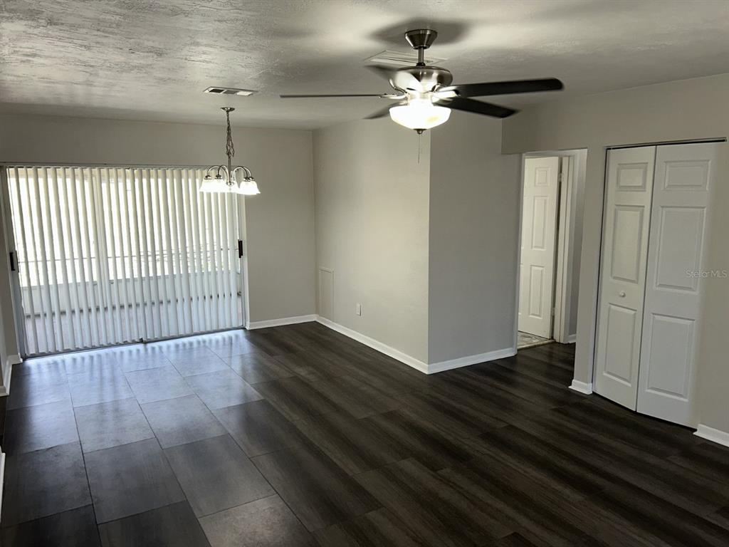 1241 Pilgrim Road Spring Hill, FL 34606 - Photo 5 of 28 an empty room with wooden floor fan and windows