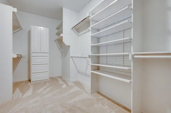 a view of walk in closet with empty racks