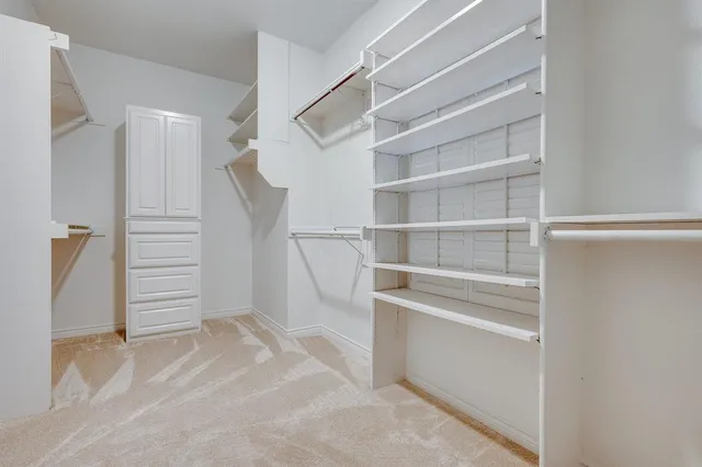 a view of walk in closet with empty racks