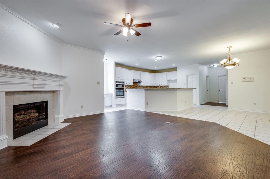3600 Leighton Ridge Drive Plano, TX 75025 - Photo 18 of 38 a view of a kitchen with a fireplace a ceiling fan and wooden floor