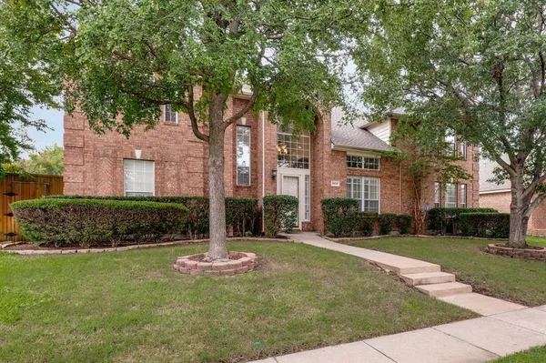 front view of a brick house with a yard