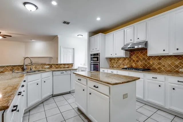 a kitchen with granite countertop white cabinets and white appliances