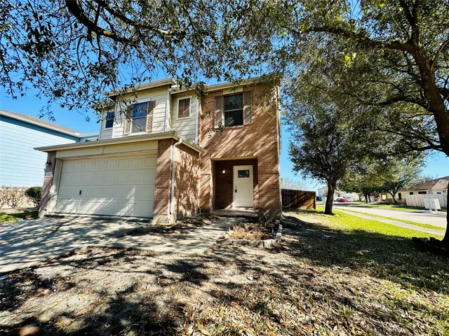 a view of a house with backyard and trees