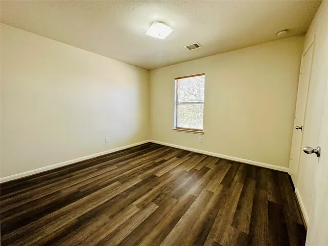 a view of an empty room and wooden floor