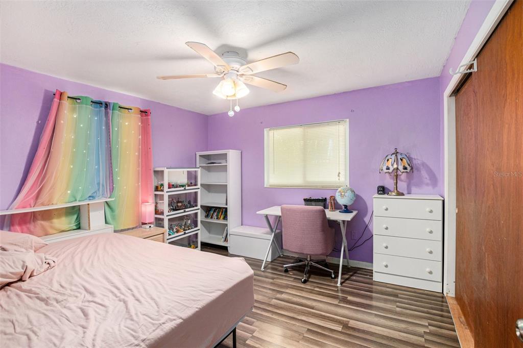 210 Red Rose Lane Inverness, FL 34452 - Photo 6 of 14 a bedroom with a bed and a chandelier