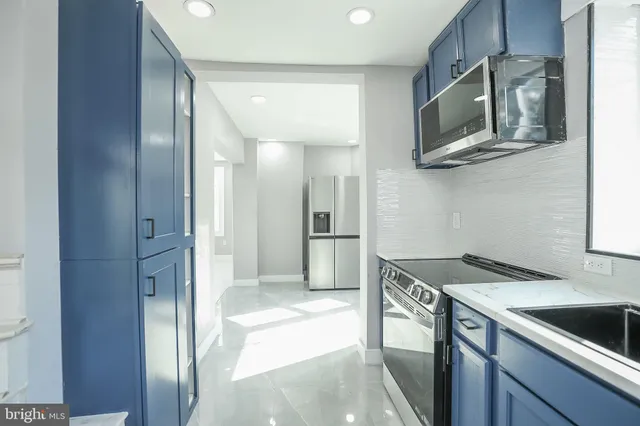 a kitchen with stainless steel appliances granite countertop a refrigerator and a sink