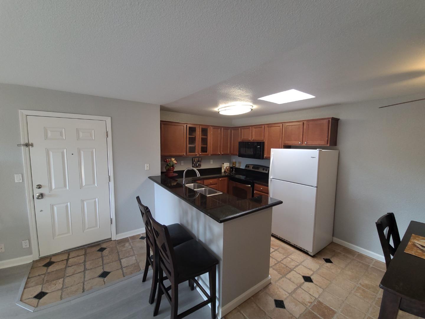 424 Dempsey Road, Unit 227 Milpitas, CA 95035 - Photo 8 of 24 a kitchen with granite countertop a sink a stove a refrigerator and cabinets