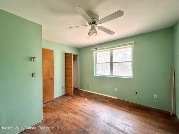 a view of an empty room with a window and a fan