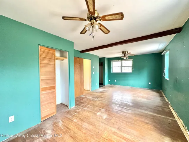a view of a livingroom with a chandelier fan and windows