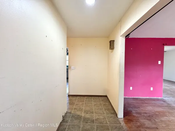 a view of a livingroom with a red door and wooden floor