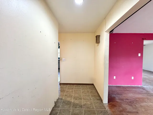 a view of a livingroom with a red door and wooden floor