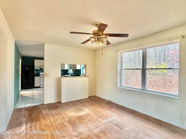 a view of a livingroom with a ceiling fan and window