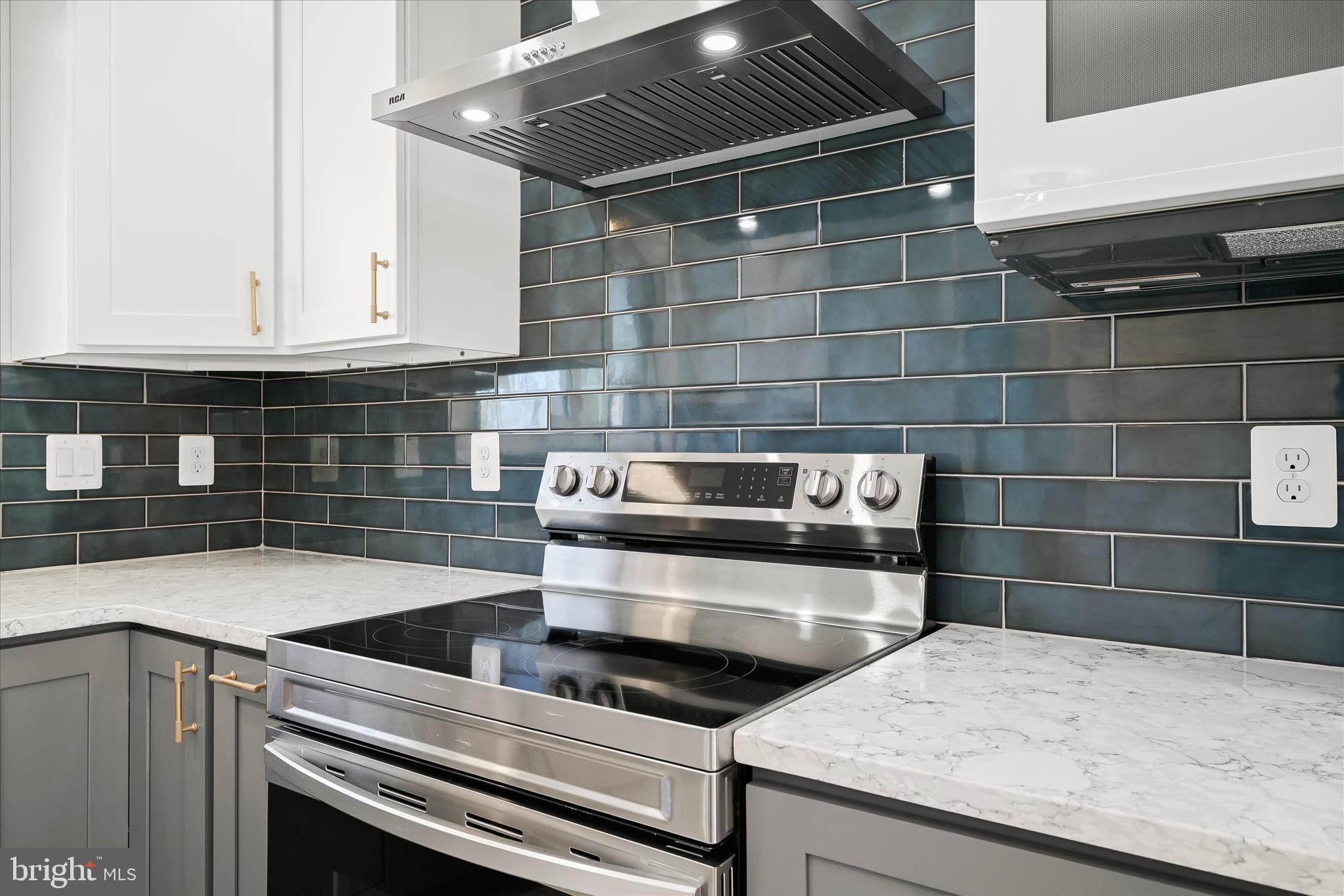 9720 Hedin Drive Silver Spring, MD 20903 - Photo 20 of 79 a kitchen with granite countertop a stove and white cabinets
