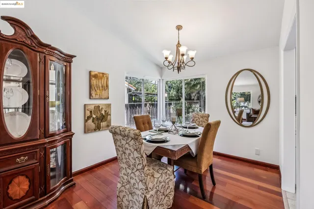 a view of a dining room with furniture a chandelier and wooden floor