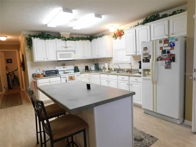 a kitchen with a table chairs refrigerator and cabinets