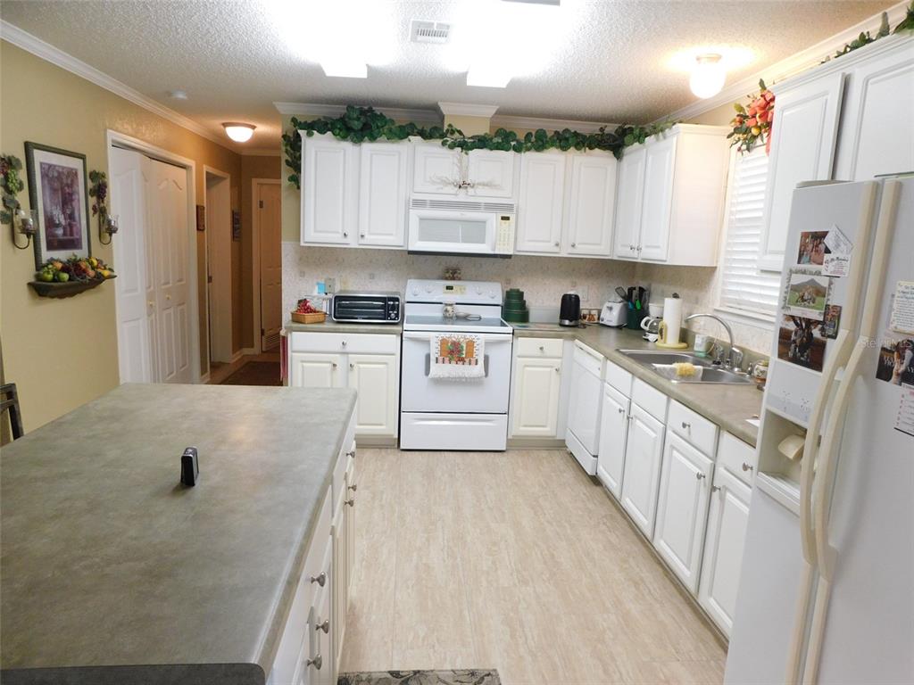 11739 Southwest Lemon Avenue Arcadia, FL 34269 - Photo 13 of 52 a kitchen with stainless steel appliances granite countertop a refrigerator sink and cabinets