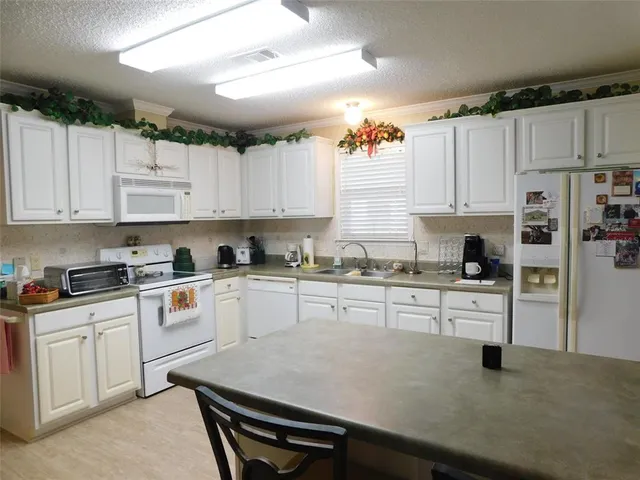 a kitchen with cabinets appliances a sink and a counter top space