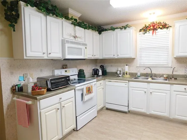 a kitchen with cabinets appliances a sink and a window
