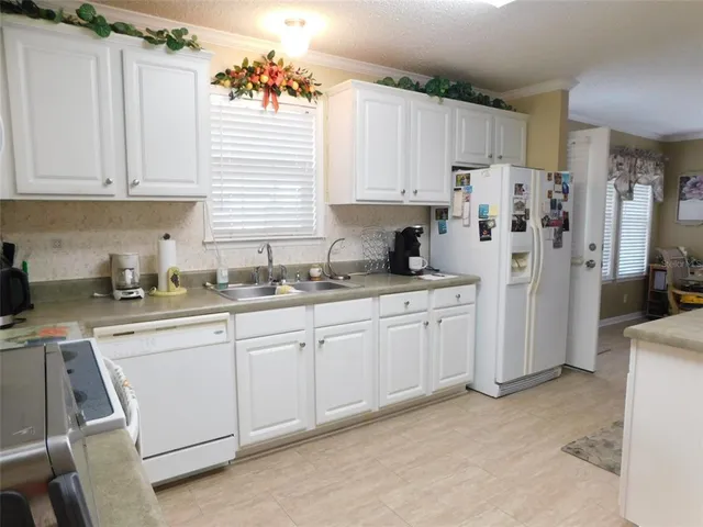 a kitchen with white cabinets and white appliances