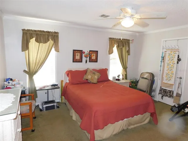 a bedroom with a bed a window and painting on the wall