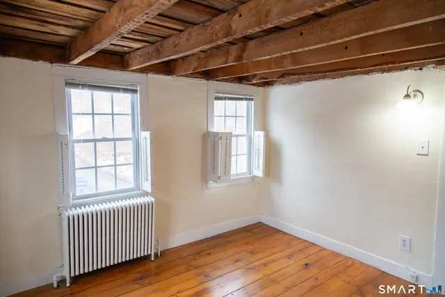 a view of empty room with wooden floor