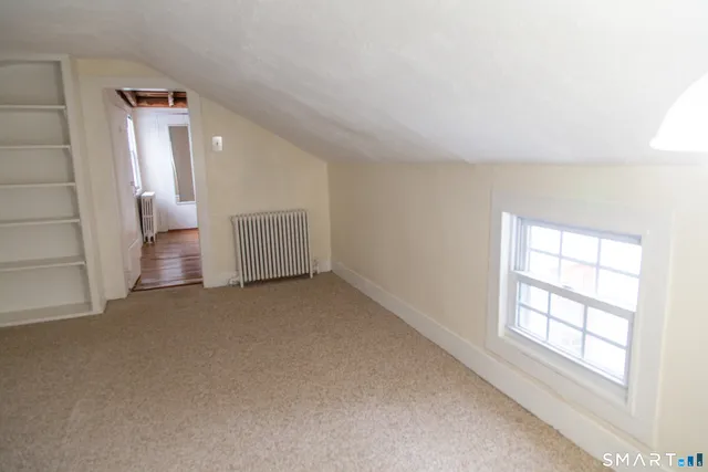 an empty room with windows and cabinet