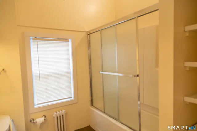 a bathroom with a shower and a window